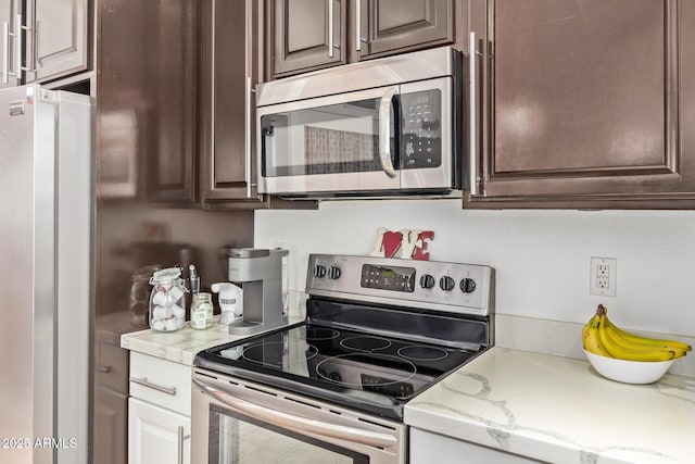 4331 E Redwood Ln, Phoenix, AZ 85048 - kitchen featuring appliances with stainless steel finishes, dark brown cabinets, and light stone countertops