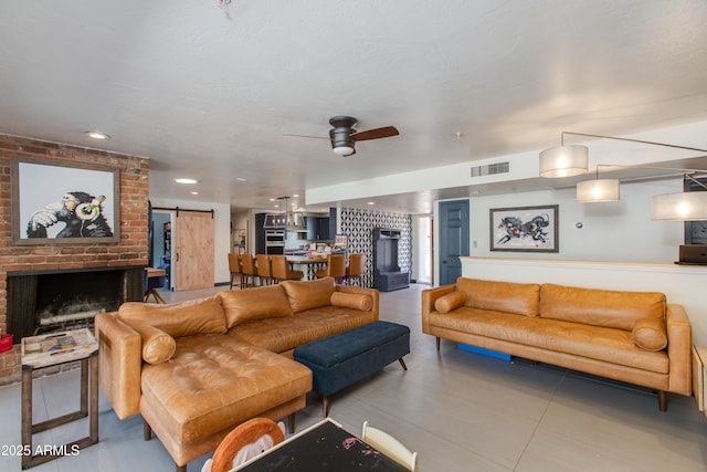 7102 E Kalil Dr, Scottsdale, AZ 85254 - living room featuring a barn door, a fireplace, ceiling fan, and tile patterned flooring