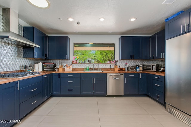 7102 E Kalil Dr, Scottsdale, AZ 85254 - kitchen with stainless steel appliances, butcher block counters, wall chimney range hood, a sink, and recessed lighting