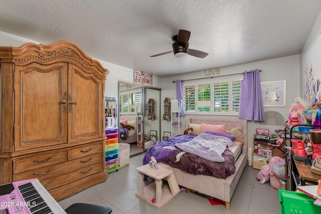 7102 E Kalil Dr, Scottsdale, AZ 85254 - bedroom featuring a closet, a textured ceiling, ceiling fan, and light tile patterned flooring