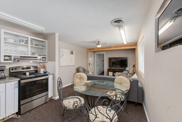 7102 E Kalil Dr, Scottsdale, AZ 85254 - kitchen with stainless steel electric range oven, under cabinet range hood, white cabinetry, and dark carpet