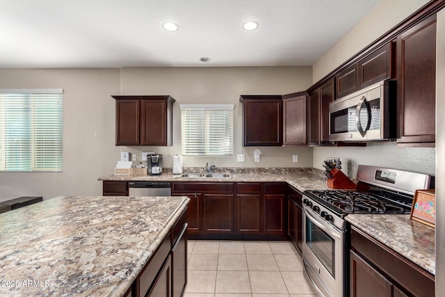 kitchen with recessed lighting, appliances with stainless steel finishes, light tile patterned flooring, a sink, and dark brown cabinetry