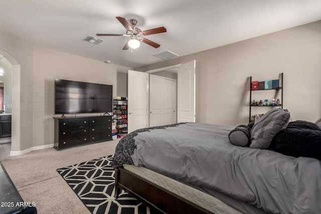 bedroom featuring baseboards, visible vents, arched walkways, a ceiling fan, and light colored carpet