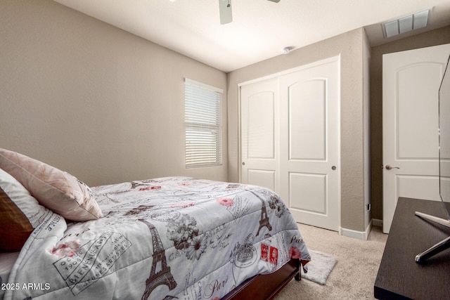 bedroom with a closet, light colored carpet, visible vents, ceiling fan, and baseboards