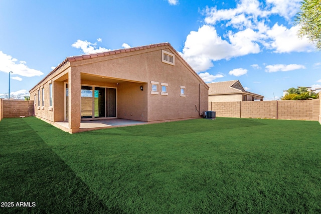 back of house with a fenced backyard, a patio, a lawn, and stucco siding