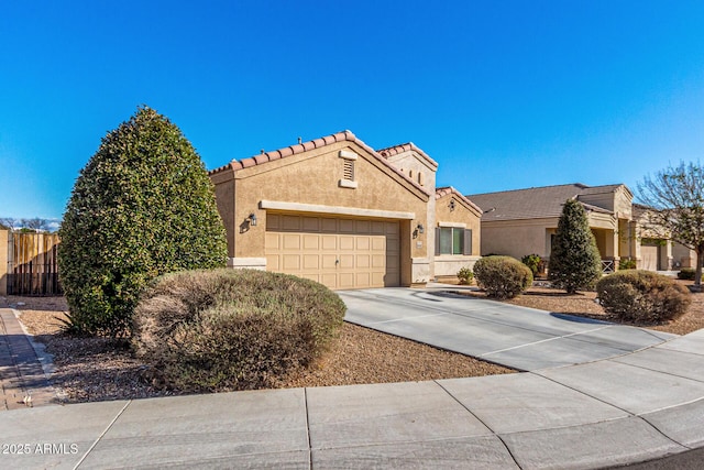 view of front of property with concrete driveway, a tiled roof, an attached garage, and stucco siding