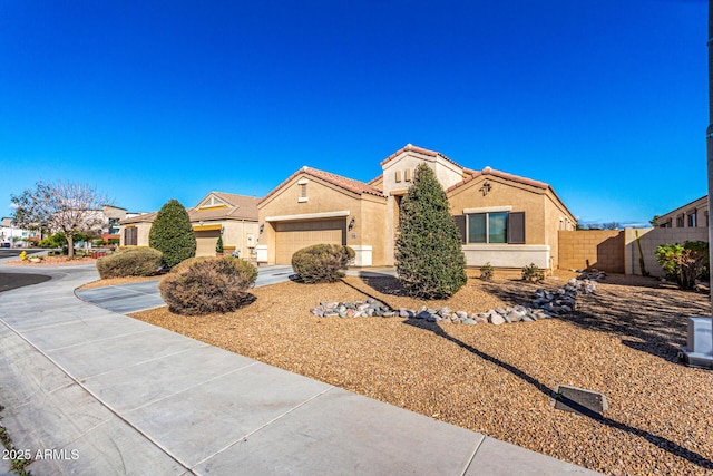 mediterranean / spanish home featuring driveway, a garage, a tiled roof, fence, and stucco siding