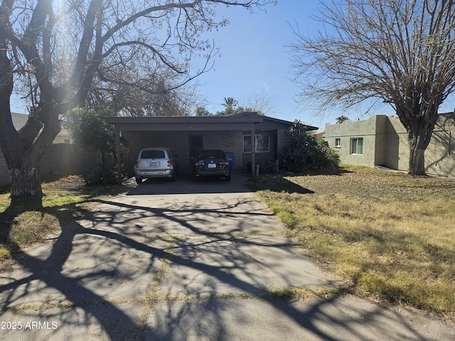 exterior space featuring driveway, a carport, and brick siding