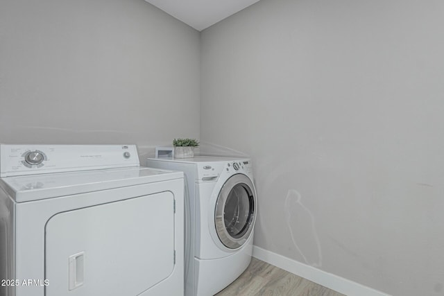 4441 N 27th Dr, Phoenix, AZ 85017 - clothes washing area with washer and clothes dryer, baseboards, and light wood-style floors