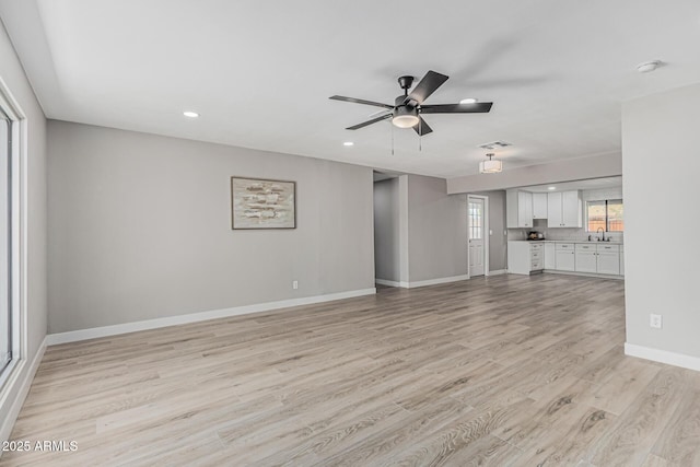 4441 N 27th Dr, Phoenix, AZ 85017 - unfurnished living room with light wood-style flooring, ceiling fan, baseboards, recessed lighting, and a sink
