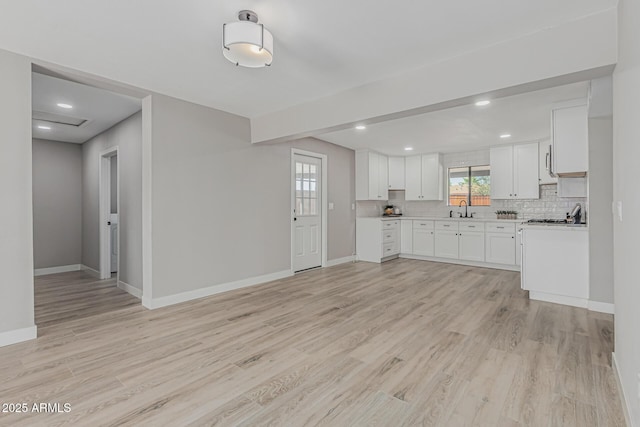 4441 N 27th Dr, Phoenix, AZ 85017 - kitchen with a sink, baseboards, light wood-style flooring, light countertops, and backsplash
