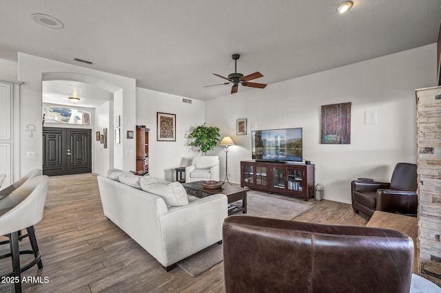 living room with ceiling fan and light hardwood / wood-style flooring