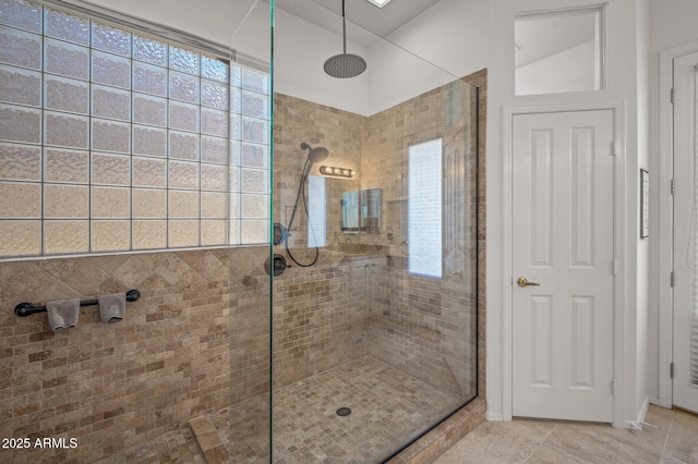 bathroom with a healthy amount of sunlight and tiled shower