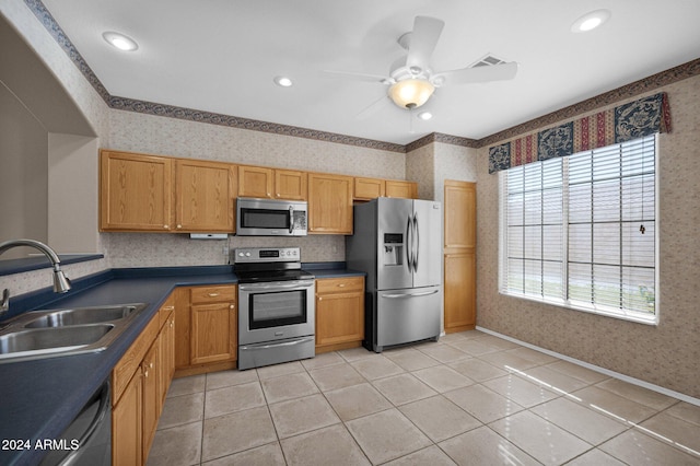 kitchen featuring sink, appliances with stainless steel finishes, light tile patterned flooring, and ceiling fan