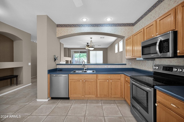 kitchen featuring light tile patterned flooring, stainless steel appliances, sink, and ceiling fan