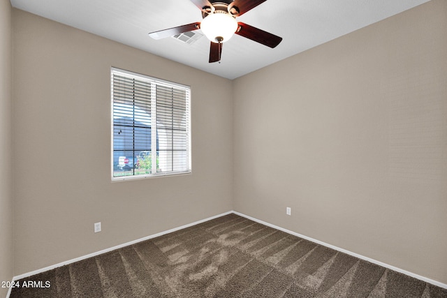 spare room with ceiling fan and carpet