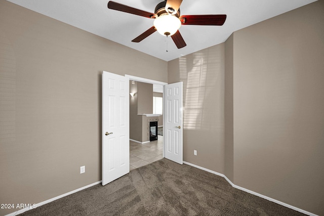 spare room with lofted ceiling, carpet floors, and ceiling fan