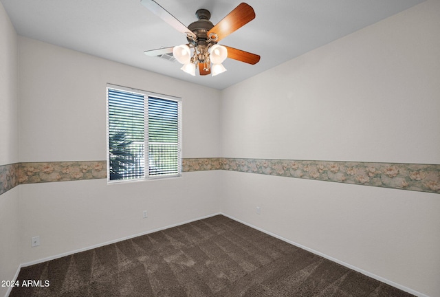 spare room featuring ceiling fan and dark colored carpet