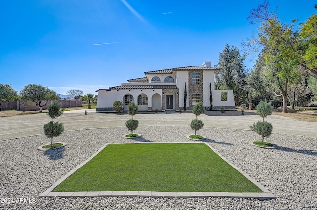 mediterranean / spanish-style home with a front lawn