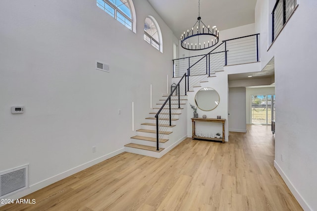 staircase featuring a notable chandelier, a high ceiling, and hardwood / wood-style flooring