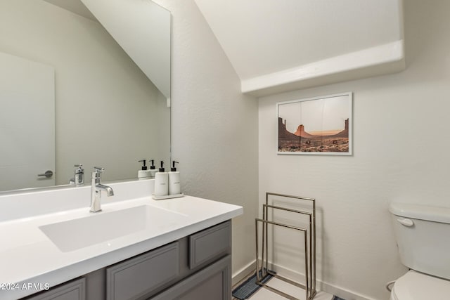 bathroom featuring lofted ceiling, vanity, and toilet