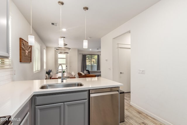 kitchen with tasteful backsplash, sink, kitchen peninsula, and decorative light fixtures