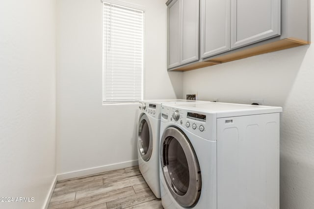 laundry area with separate washer and dryer, cabinets, and light wood-type flooring