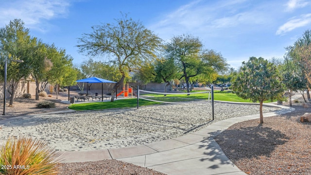 view of property's community with volleyball court, a yard, and fence