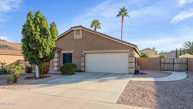 view of front of home with a tile roof, stucco siding, fence, a garage, and driveway