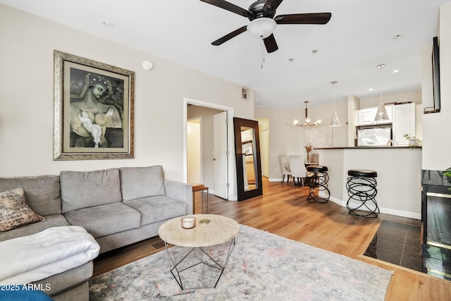 3633 N 3rd Ave Unit 1035, Phoenix, AZ 85013 - living area with a chandelier, light wood-type flooring, a ceiling fan, and baseboards
