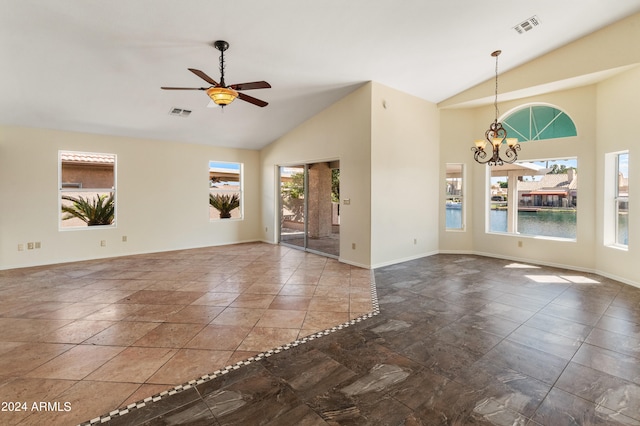 spare room featuring ceiling fan with notable chandelier, high vaulted ceiling, and plenty of natural light