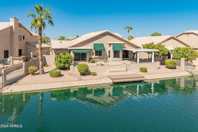 rear view of house with a patio and a water view