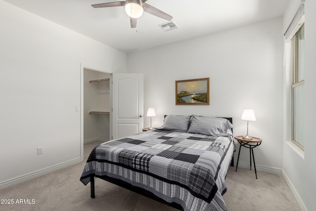 bedroom featuring light carpet, baseboards, and a spacious closet