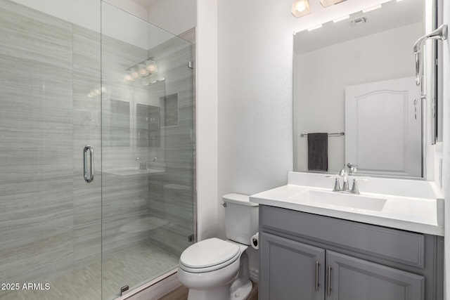 full bath featuring a stall shower, vanity, and toilet