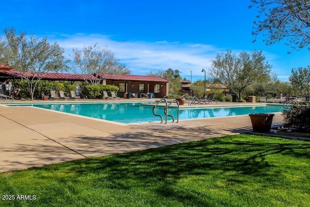community pool featuring a lawn and a patio