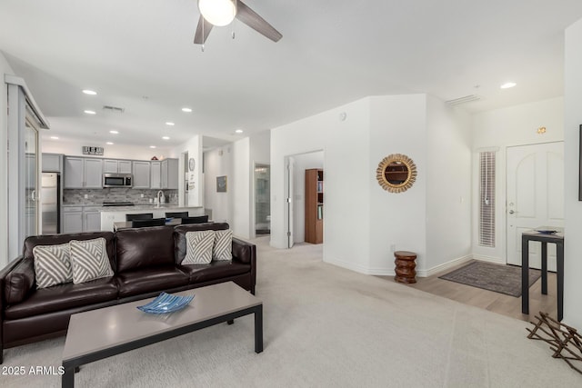 living area with a ceiling fan, recessed lighting, and baseboards
