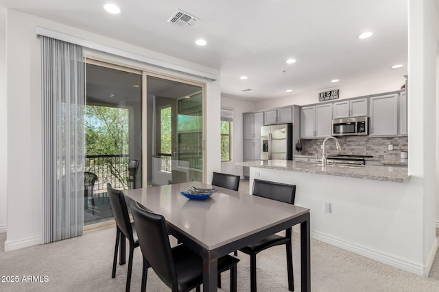 dining space with light colored carpet, recessed lighting, and baseboards