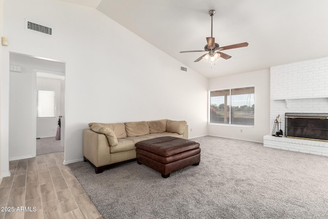 living room with a brick fireplace, high vaulted ceiling, and ceiling fan