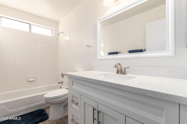 full bathroom featuring toilet, tiled shower / bath, wood-type flooring, and vanity