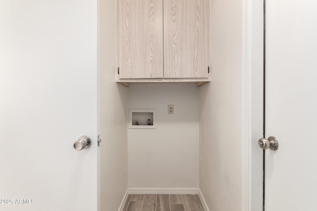 laundry room featuring cabinets, wood-type flooring, and hookup for a washing machine