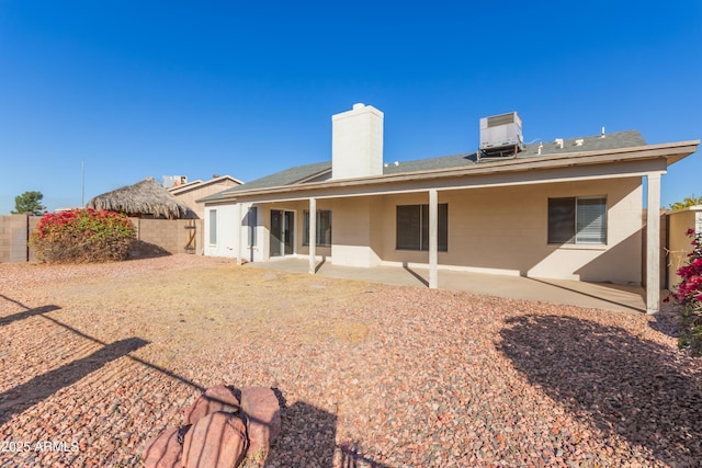 back of property with a patio area and central AC