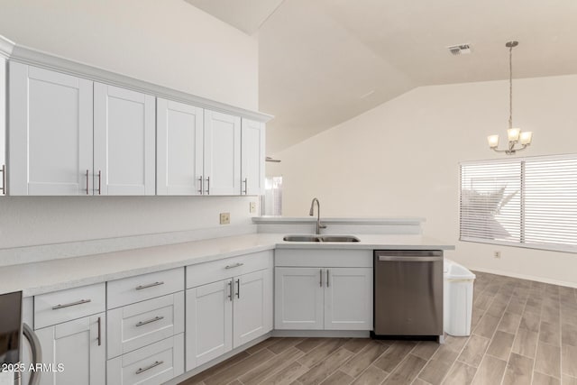 kitchen with hanging light fixtures, vaulted ceiling, stainless steel dishwasher, white cabinets, and sink