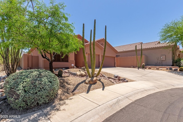 14657 N 103rd Way, Scottsdale, AZ 85255 - view of front of house featuring a garage, driveway, a tiled roof, and stucco siding