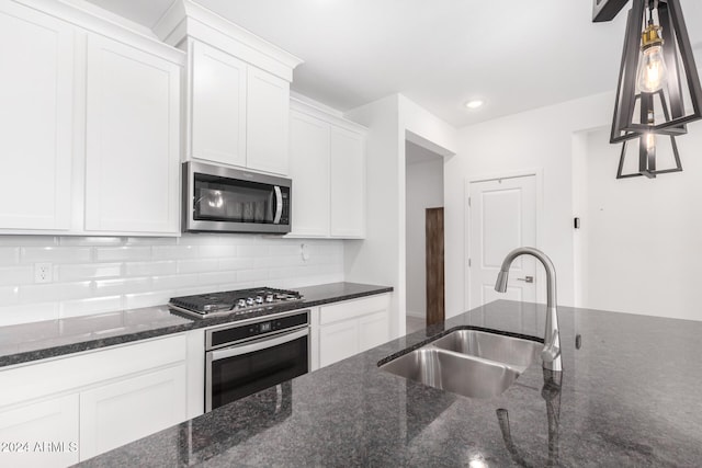 kitchen with white cabinets, dark stone countertops, sink, and stainless steel appliances