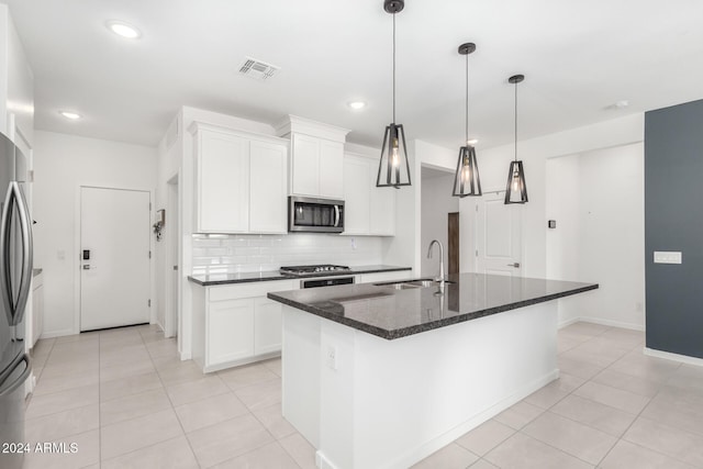 kitchen with white cabinetry, sink, backsplash, a center island with sink, and appliances with stainless steel finishes