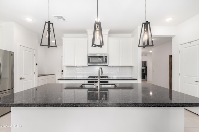 kitchen with a kitchen island with sink, hanging light fixtures, and stainless steel appliances