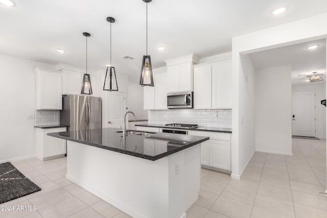 kitchen featuring white cabinets, stainless steel appliances, a center island with sink, and sink