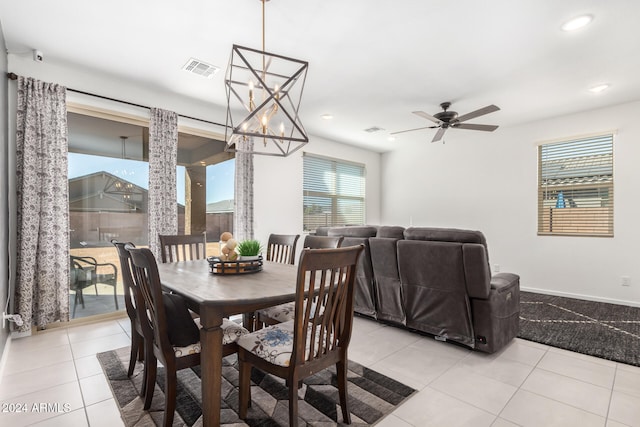 dining area with ceiling fan with notable chandelier and light tile patterned flooring