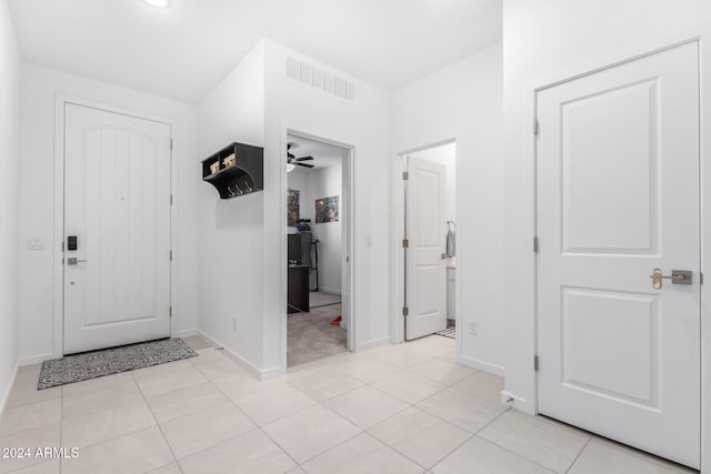 tiled foyer featuring ceiling fan