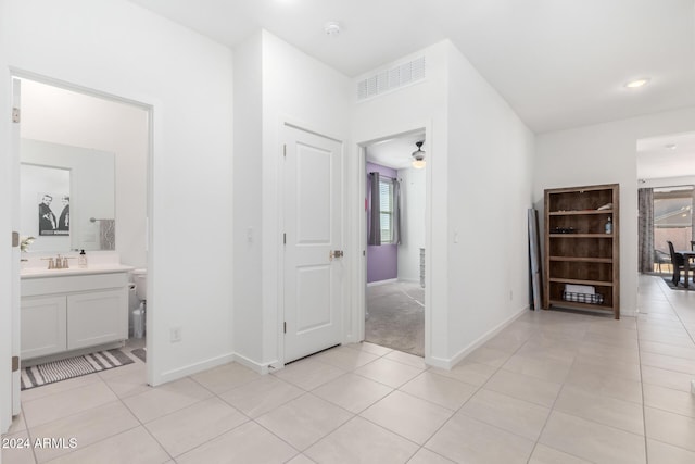 hallway with light tile patterned floors and sink